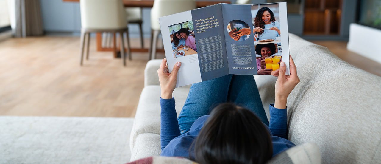 woman reading at traditional marketing piece a magazine