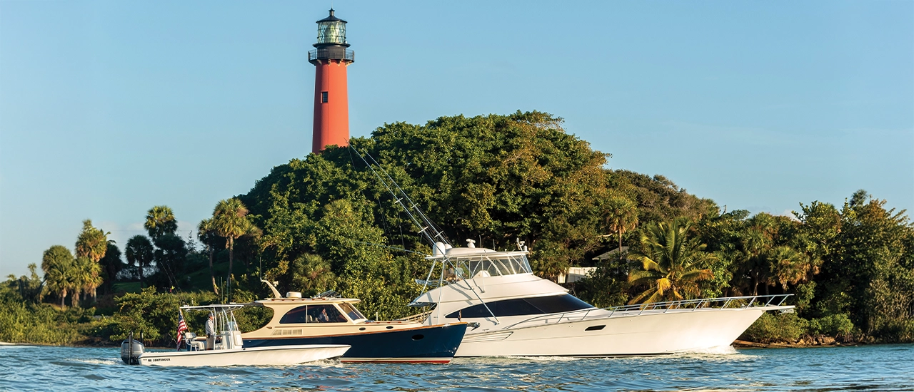 Boats passing the red Jupiter Inlet Lighthouse in Palm Beach County.