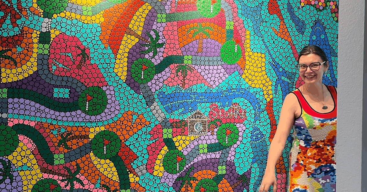 artist posing in front of her artwork