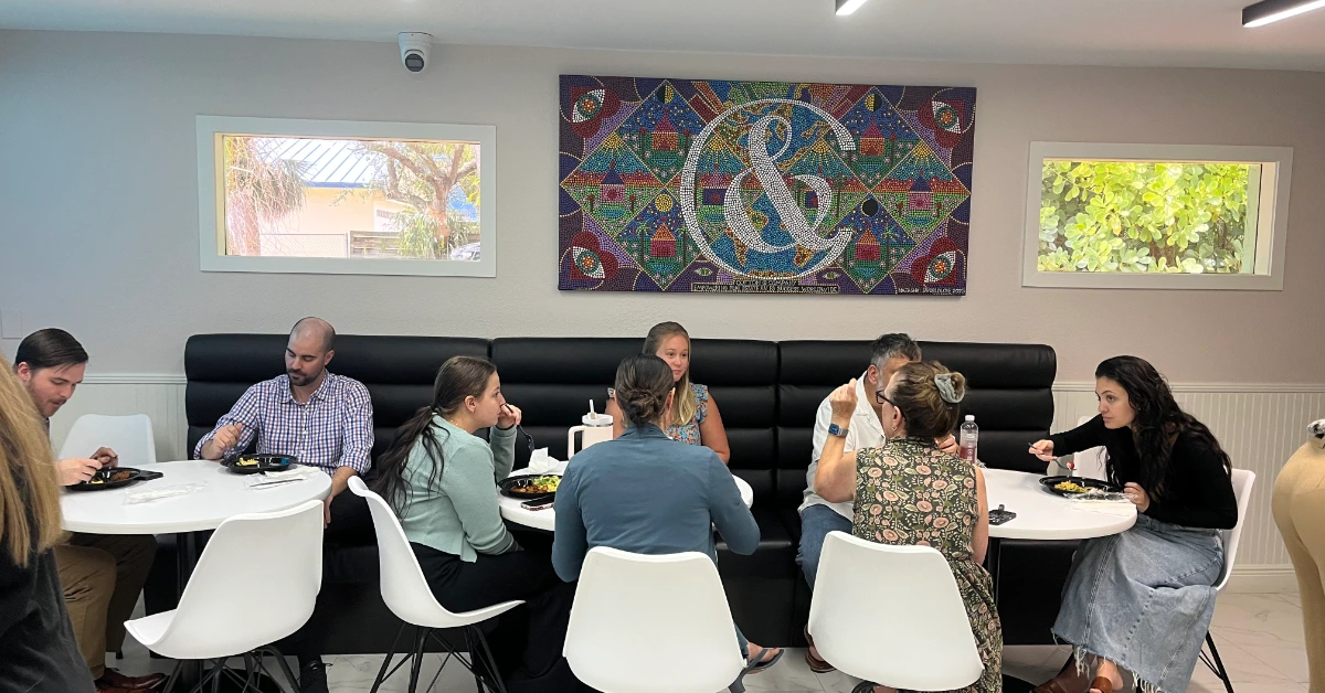 People dining together in modern café with mosaic wall art