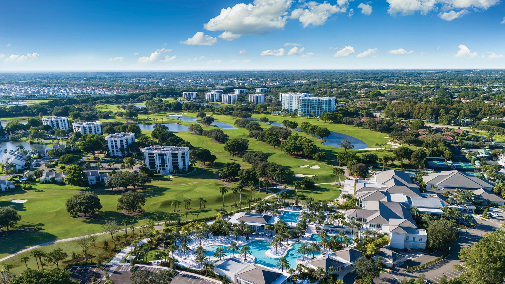 Aerial view of Boca West Country Club with golf courses, lakes, pools, and residences.