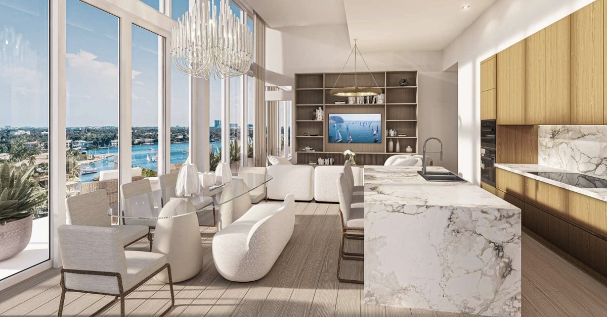 Luxury open concept living space featuring a marble kitchen island floor to ceiling windows and sweeping waterfront views in an upscale coastal residence